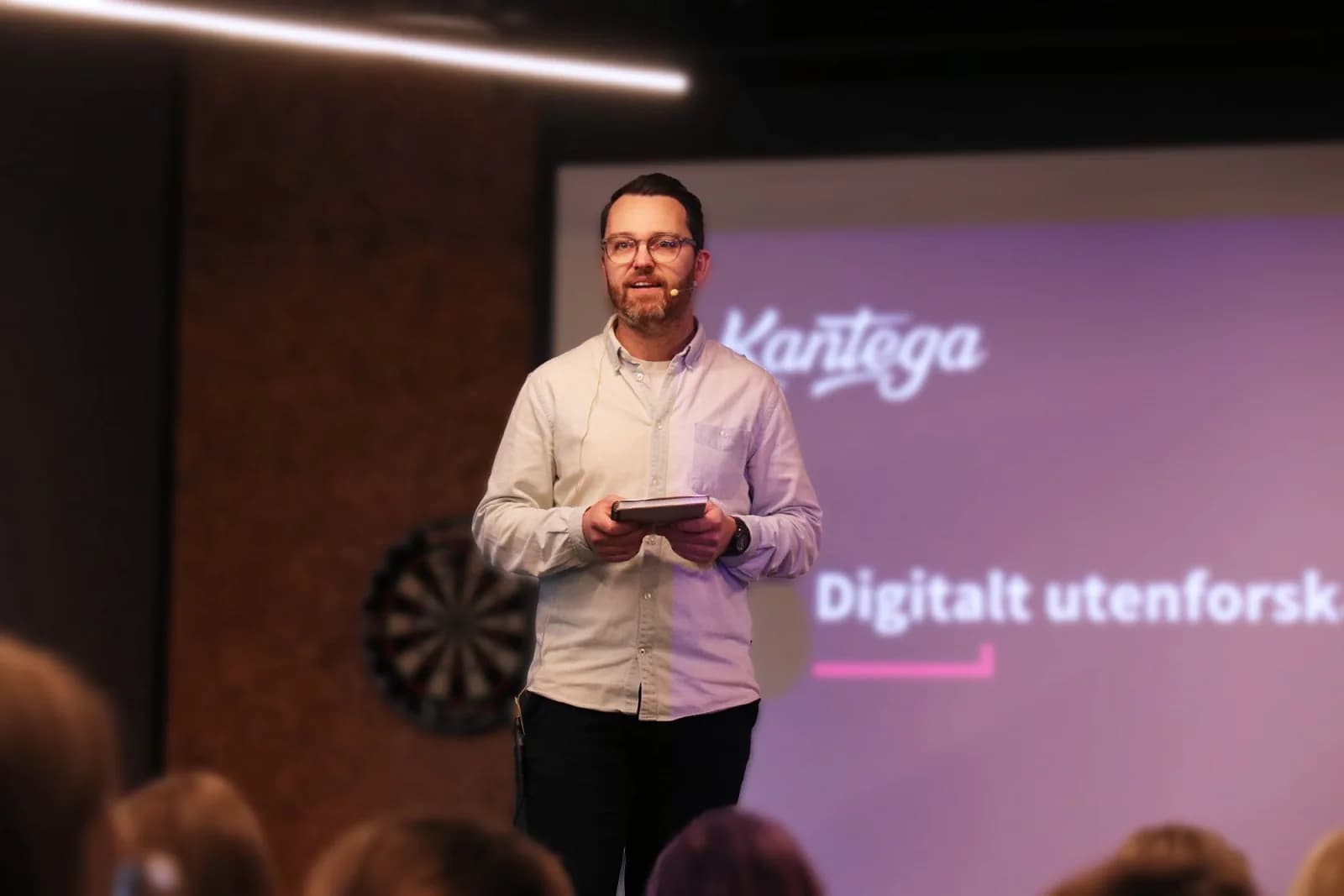 Hans-Jørgen Løken holder foredrag foran en skjerm med Kantega-logo og tittelen «Digitalt utenforskap»