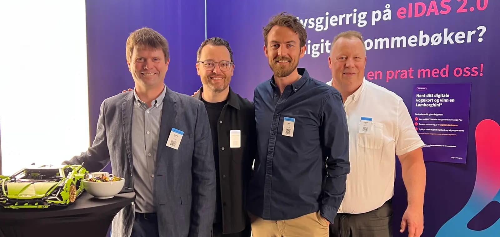 Fire fra Kantega står foran en stand med teksten «Nysgjerrig på eIDAS 2.0 og digitale lommebøker?»